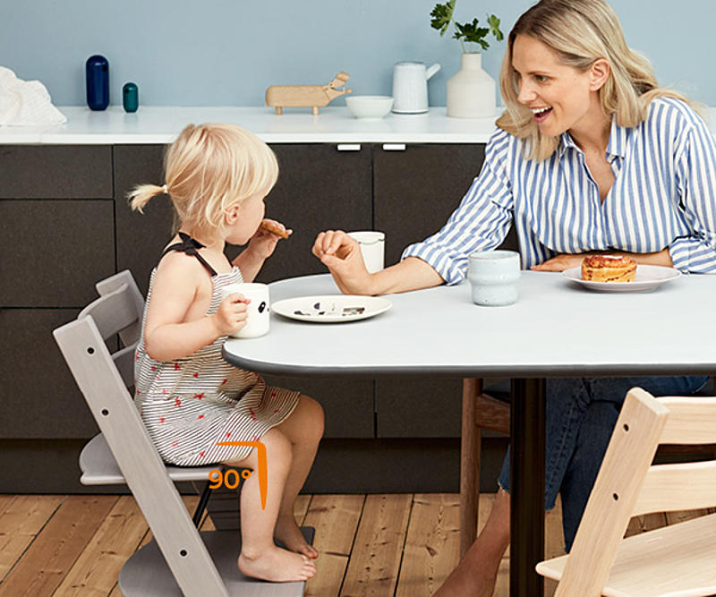 Mother having snacks with her daughter sitting on Tripp Trapp chair